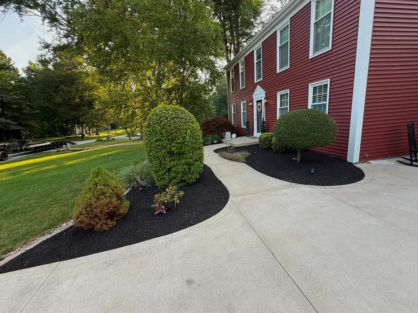 Black mulch beds and trimmed shrubs lining a front walkway