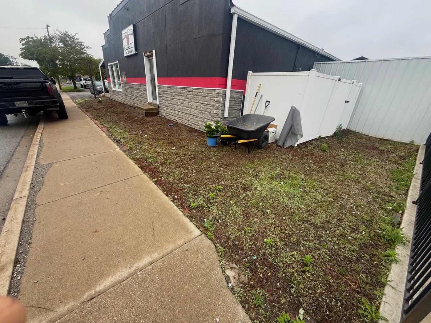 Bare dirt beds along the building before landscaping